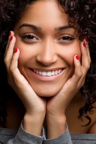 Woman smiling with her hands cupping her chin